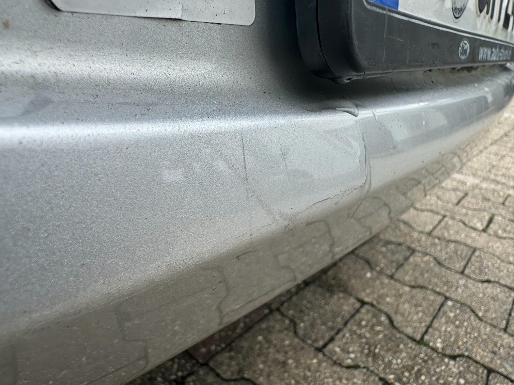 Parkschaden mit Kratzern am silbernen Stoßfänger